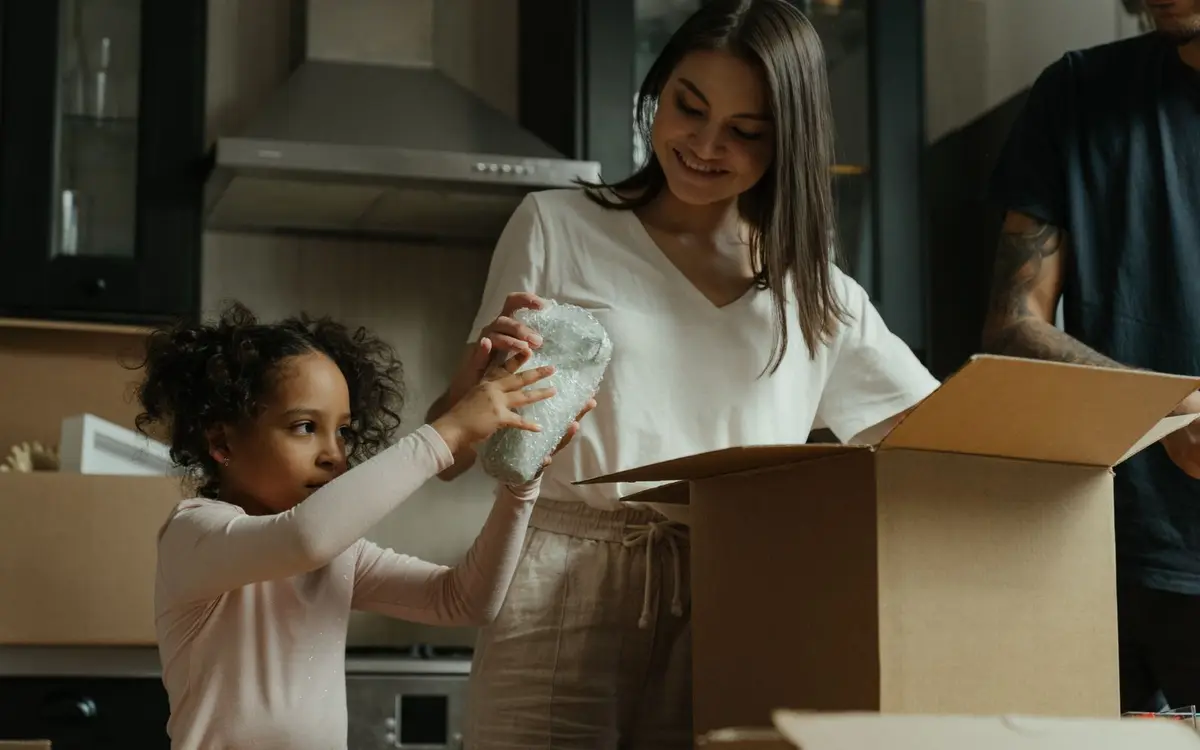 A family unpacking boxes in the kitchen of their new home
