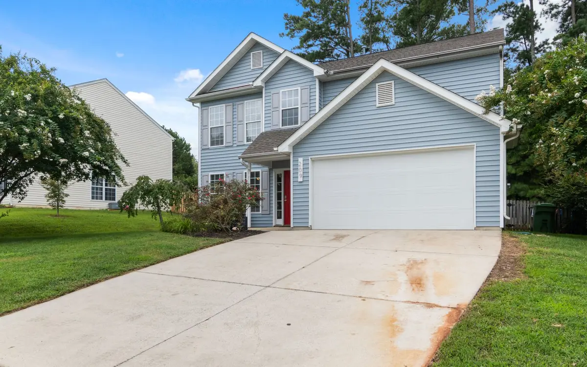 A two-story suburban house with a long driveway